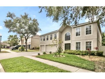 Traditional home featuring a manicured lawn, a two-car garage, and a neutral color palette at 2658 Palmetto Ridge Cir, Apopka, FL 32712