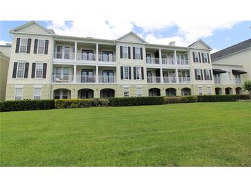 Elegant condo building featuring multiple balconies and a well-manicured lawn at 280 Celebration Blvd # 208, Kissimmee, FL 34747