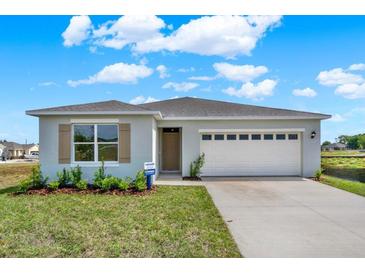 Charming single-story home featuring a two-car garage, landscaped yard, and neutral color palette at 3018 Salisbury Ave, Haines City, FL 33844