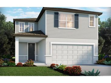 Charming two-story home featuring a two-car garage, covered porch, and well-manicured landscaping at 3892 Giorgio Dr, Winter Haven, FL 33884