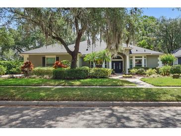 Charming single-story home with manicured lawn, mature trees, and a welcoming front entrance at 4411 Little Water St, Orlando, FL 32817