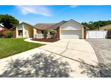 Charming single-story home with a well-manicured lawn, driveway, and two-car garage at 4993 Heatherstone Pl, Orlando, FL 32812
