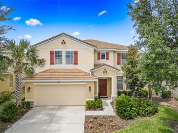Charming two-story home with a well-maintained lawn, terracotta tile roof, and red shutters at 5156 Oakbourne Ave, Davenport, FL 33837
