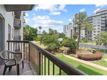 Relax on the balcony overlooking lush grounds, pool, and city skyline at 6165 Carrier Dr # 1304, Orlando, FL 32819