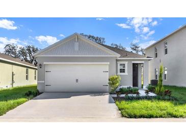 Charming single-Gathering home featuring a two-car garage, manicured lawn, and inviting curb appeal at 805 Ambleside Dr, Haines City, FL 33844