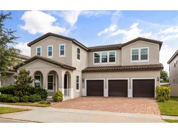 Charming two-story home with three-car garage and beautifully landscaped front yard at 9567 Meadow Hunt Way, Winter Garden, FL 34787