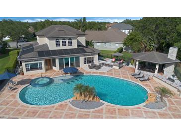 An inviting backyard with a large pool, spa, cabana, and outdoor kitchen perfect for entertaining at 1710 Bridgets Ct, Kissimmee, FL 34744