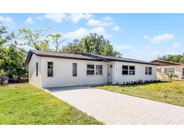 Charming single-story home featuring a white exterior, brick driveway, and well-maintained lawn at 2105 9Th Ne St, Winter Haven, FL 33880
