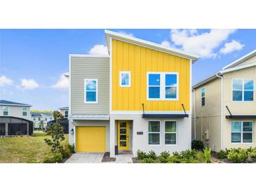 Modern two-story home features a bright yellow accent wall and attached garage at 2936 Protagonist St, Kissimmee, FL 34746