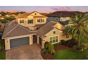 A well-manicured home displays a tiled roof, a spacious three-car garage, and brick paver driveway at 3647 Farm Bell Pl, Lake Mary, FL 32746