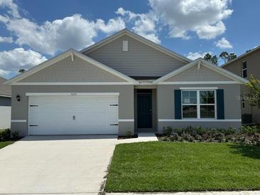 Charming single-story home featuring a two-car garage, manicured lawn, and neatly landscaped flower beds at 5075 Marshelder, Apopka, FL 32712