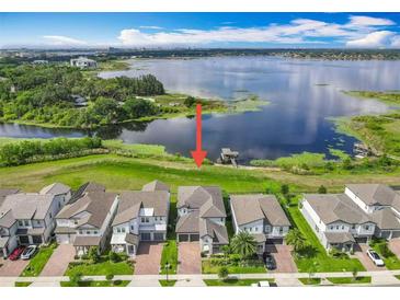 Beautiful waterfront property showcasing lush green lawns and lake access with a private dock at 7398 Alpine Butterfly Ln, Orlando, FL 32819