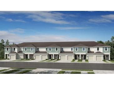 New townhome exteriors showcasing covered entries, single car garages, and beautifully landscaped front yards at 7751 Waterscape Dr, Groveland, FL 34736