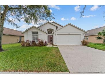 Charming single-story home with a well-manicured lawn and attached two-car garage at 7905 Golden Pond Cir, Kissimmee, FL 34747