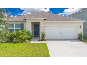 Charming single-story home with a well-manicured lawn and an attached two-car garage at 1312 Sugarwood St, Davenport, FL 33837