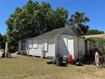 Exterior view of home featuring white siding and overgrown lawn at 1708 W 16Th St, Sanford, FL 32771