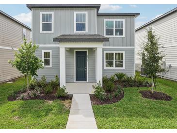 Charming two-story home with gray siding, well-manicured landscaping, and inviting front entrance at 2467 Zuni Road, St Cloud, FL 34771