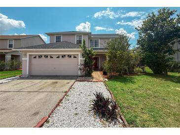 Charming two-story home featuring a well-manicured front yard, two-car garage, and beautiful landscaping at 2530 Baykal Dr, Kissimmee, FL 34746