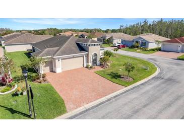 Beautiful single Gathering home with a two car garage, brick driveway, and well-maintained lawn at 428 Bel Air Way, Kissimmee, FL 34759