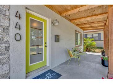 Inviting front porch with natural wood accents, decorative chairs and a vibrant green door at 440 E Crystal Lake St, Orlando, FL 32806
