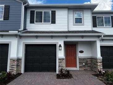 Charming townhome with brick driveway, stone accents, one-car garage, and inviting front entry at 5099 Prairie Preserve Run, St Cloud, FL 34772