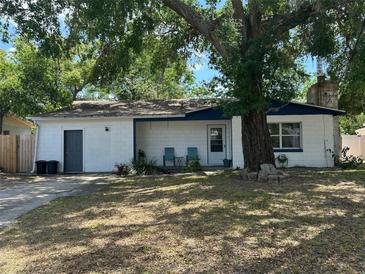 Charming single-story home with a front porch, mature tree, and white siding at 890 Emerald Dr, Mount Dora, FL 32757