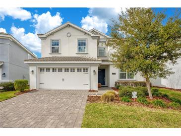 Charming two-story home featuring a paver driveway, two-car garage, and well-maintained landscaping at 9034 Stinger Dr, Davenport, FL 33896