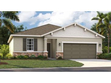 Charming single-Gathering home features a stone accent facade, two-car garage and well-manicured lawn at 1219 Normandy Dr, Haines City, FL 33844