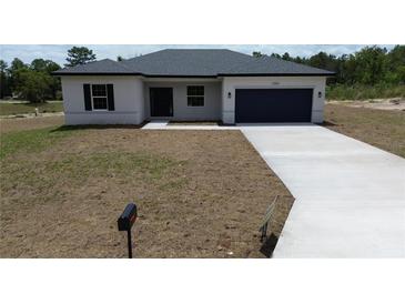 Charming single-story home with a well-manicured lawn and a paved driveway leading to an attached garage at 13253 Sw 83Rd Cir, Ocala, FL 34473
