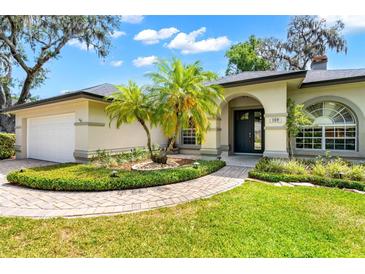 Beautiful home featuring well-manicured landscaping and a covered front entryway at 169 Winding Oaks Ln, Oviedo, FL 32765