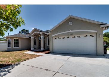 Charming home featuring a two-car garage and a well-maintained front yard with mature landscaping at 2300 Dawnwood Ln, Orlando, FL 32809