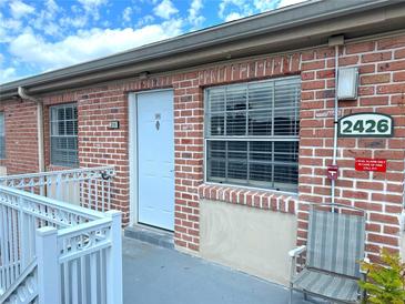Brick condo with white door and trim, featuring updated windows and convenient access at 2426 Branch Way # 200, Maitland, FL 32751