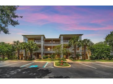 Attractive condominium building with tropical landscaping, ample parking, and private balconies for each unit at 304 Rum Run # 304, Davenport, FL 33897