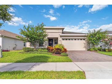 Beautiful home with a well-manicured lawn and landscaped front yard and a brick driveway at 3397 Sagebrush St, Harmony, FL 34773