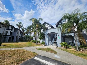 Exterior view of condo building with lush landscaping, walkways, and ample parking at 5525 Pga Blvd # 4611, Orlando, FL 32839