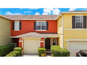 Inviting two-story townhome featuring an attached one-car garage and well-manicured landscaping at 725 Cresting Oak Cir # 117, Orlando, FL 32824