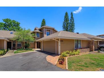 Inviting exterior showcasing a well-maintained, two-story home with a two-car garage and tastefully landscaped front yard at 7254 Della Dr, Orlando, FL 32819