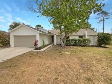 Charming single-story home with a stone accent facade, attached garage, and a well-maintained front yard at 9345 Buttonwood St, Orlando, FL 32825