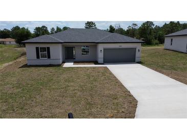Charming single-story home with a well-manicured lawn and a two-car garage at 13247 Sw 83Rd Cir, Ocala, FL 34473