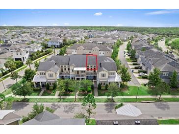 Beautiful three-story townhome with manicured landscaping and a charming front porch and balcony at 13865 Granger Ave, Orlando, FL 32827
