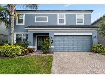 Charming two-story home featuring a well-maintained lawn, vibrant landscaping, and a two car garage at 15210 Montesino Dr, Orlando, FL 32828