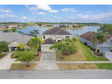 Stunning lakefront home featuring lush landscaping, a spacious driveway, and an attached two-car garage at 2803 Boating Blvd, Kissimmee, FL 34746