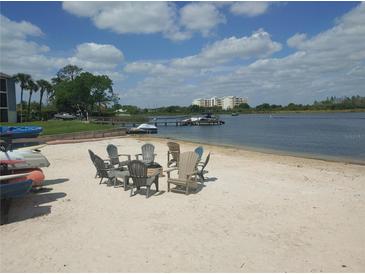 Enjoy lakefront living with a sandy beach area with chairs and a fire pit by the water at 4109 Fairview Vista Pt # 315, Orlando, FL 32804