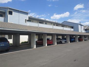 Exterior view of the covered parking area under a light blue, multi-story building at 4109 Fairview Vista Pt # 315, Orlando, FL 32804