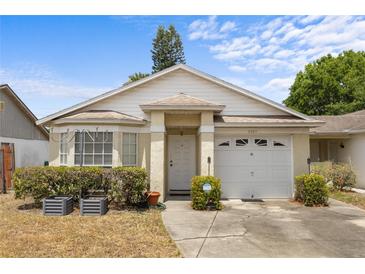 Charming single-story home featuring a well-maintained lawn, inviting entrance, and attached garage at 4561 Heritage Oak Dr, Orlando, FL 32808