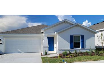 Charming single-Gathering home featuring a bright blue front door and white exterior at 707 Staffora St, Haines City, FL 33844