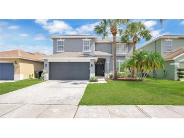 Charming two-story home featuring a gray exterior, well-manicured lawn, and a two-car garage at 726 Lake Biscayne Way, Orlando, FL 32824