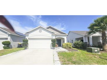 Charming single-story home with a well-maintained lawn and attached two-car garage at 853 Bocavista Ct, Davenport, FL 33896