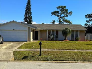 Charming single-story home boasts a well-maintained lawn, mature trees, and an attached two-car garage at 909 Royalton Rd, Orlando, FL 32825