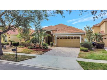Charming single-story home boasting a tile roof, arched entryway, and well-manicured landscaping at 11556 Via Lucerna Cir, Windermere, FL 34786